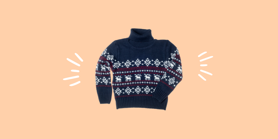 A navy, knitted holiday sweater is super imposed on a peach background